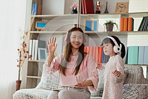 Asian child having fun and dancing with her mother in a room, active leisure and lifestyle concept