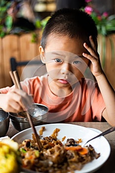 Asian child having lunch at the restaurant