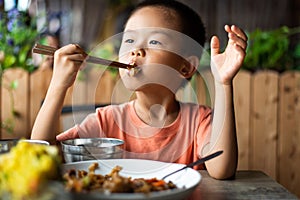 Asian child having lunch at the restaurant