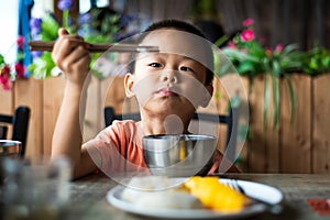 Asian child having lunch at the restaurant