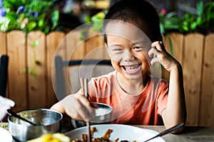 Asian child having lunch at the restaurant photo