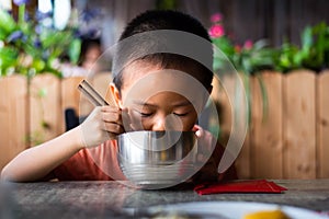 Asian child having lunch at the restaurant photo