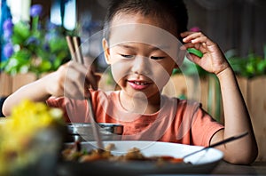 Asian child having lunch at the restaurant photo