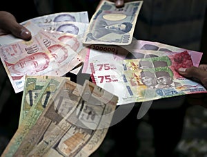 Asian child holding Indonesian rupiah, Singapore dollar, Saudi Arabia riyal, and Japan Yen money, selected focus