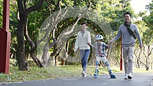 Asian child learning roller skating outdoors in park