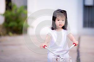Asian child little girl is riding a bicycle on the road. Children ride a tricycle exercise bike.