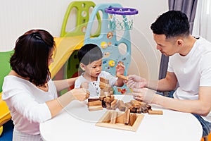 Asian child and parents playing with wooden blocks in the room at home. A kind of educational toys for preschool and kindergarten