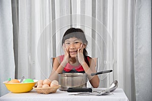 Asian child playing a chef at home.