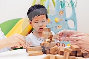 Asian child playing with wooden blocks in the room at home. A kind of educational toys for preschool and kindergarten kids