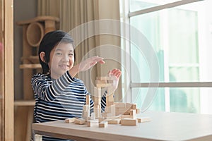 Asian child playing wooden bolck in the living room