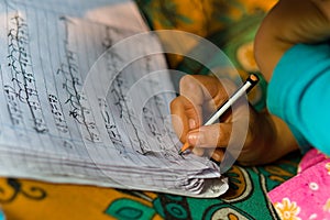 17.12.2022. asian child practicing handwritting with a pencil on copy . India photo
