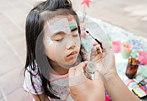 asian Child preschooler with face painting. Make up.