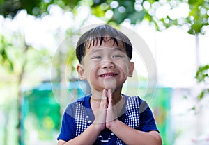 Asian child put the palms of the hands together in salute.