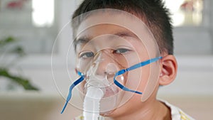 Asian child using nebuliser mask equipment alone have smoke