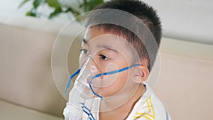 Asian child using nebuliser mask equipment alone have smoke