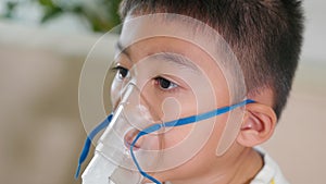 Asian child using nebuliser mask equipment alone have smoke