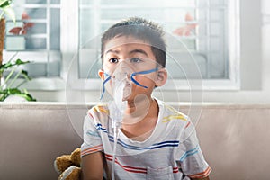 Asian Child using nebulizer mask equipment alone have smoke