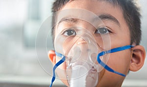 Asian Child using nebulizer mask equipment alone have smoke