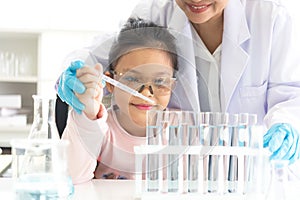Asian children analyzing study evaluating microscope with scientist.