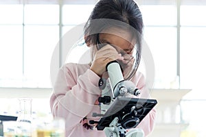 Asian children analyzing study evaluating microscope with scientist. photo