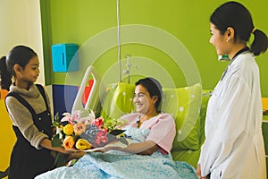 Asian children Come to visit the patient and give the flowers with the doctor smiling