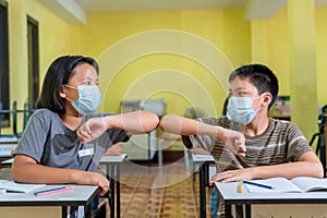 Asian children with face mask back at school after covid-19 quarantine and lockdown, greeting