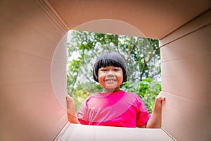 Asian children playing in cardboard boxes