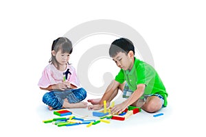 Asian children playing toy wood blocks, isolated on white background.