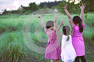 Asian children raise hands and playing together