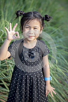 Asian children with smiling face and hand sign for okay