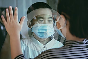 Asian children wearing protection mask standing at home door