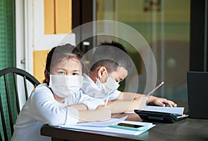 Asian children wearing protection mask study at home school