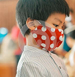 Asian children is wearing red mask for protection againts Coronavirus COVID-19