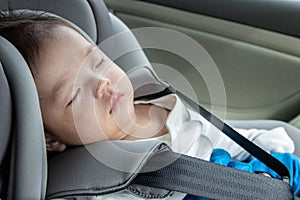 Asian Chinese baby boy asleep while in child safety car seat