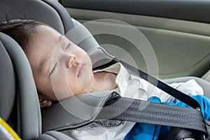 Asian Chinese baby boy asleep while in child safety car seat