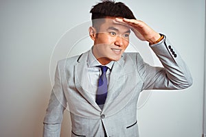 Asian chinese businessman wearing suit and tie standing over isolated yellow background very happy and smiling looking far away