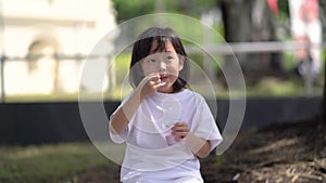 Asian chinese child girl eating ice cream hungrily for the first time