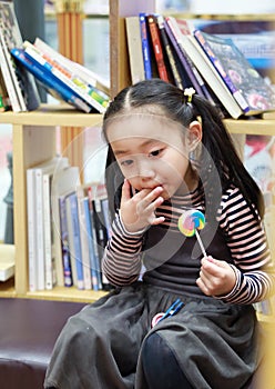 Asian chinese child licking a lollipop