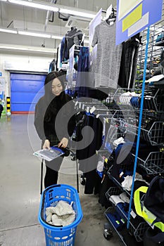 Asian chinese choosing clothes , clothes area in Decathlon store