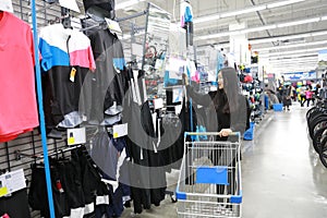 Asian chinese choosing clothes , clothes area in Decathlon store