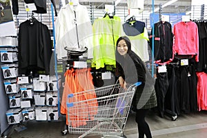 Asian chinese choosing clothes , clothes area in Decathlon store