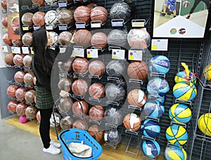 Asian chinese choosing Soccer balls, Soccer ballsarea in Decathlon store