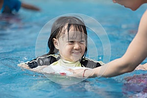 Asian Chinese family playing in swimming pool