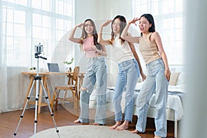 Asian Chinese female friends dancing in front of a mobile phone