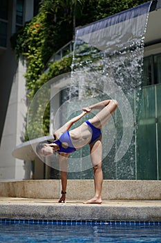 Asian Chinese female Yogi practising by the swimming pool