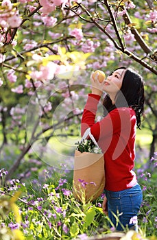 Asian Chinese freedom woman smiling and smell fruit in nature in spring outdoor