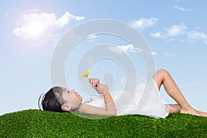 Asian Chinese girl lying on the grass and holding flower