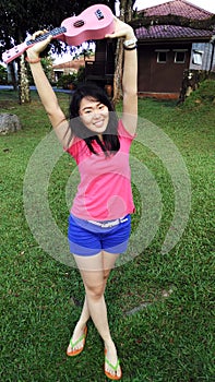 Asian chinese girl playing ukulele