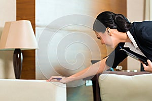 Asian Chinese housekeeper controlling hotel room