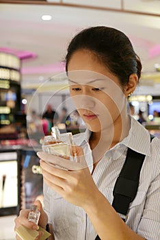 Asian chinese lady assessing her purchase in Duty Free